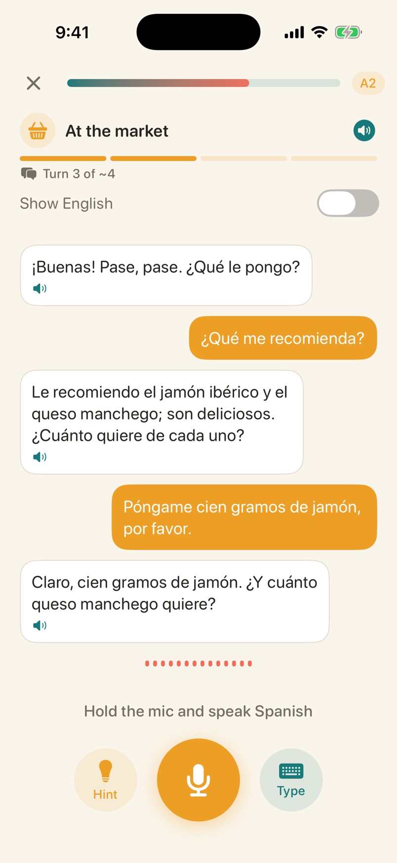 Voxolo live conversation at the market: the vendor recommends jamón ibérico and Manchego cheese, the learner replies asking for 100 grams, with turn progress and hold-to-talk microphone controls
